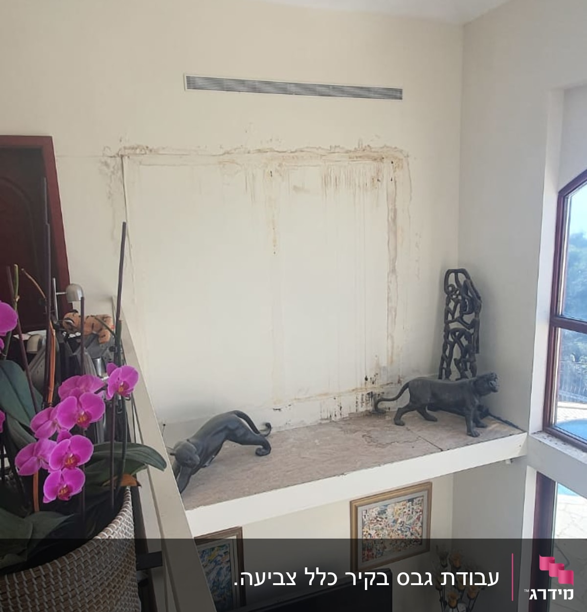 קיר עם סימני רטיבות ותקרה חשופה